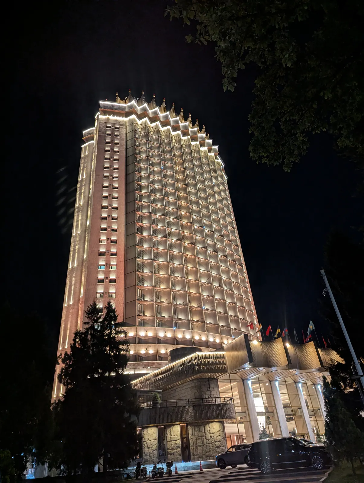 Hotel Kazakhstan lit up at night, a recognizable Soviet-era landmark in Almaty