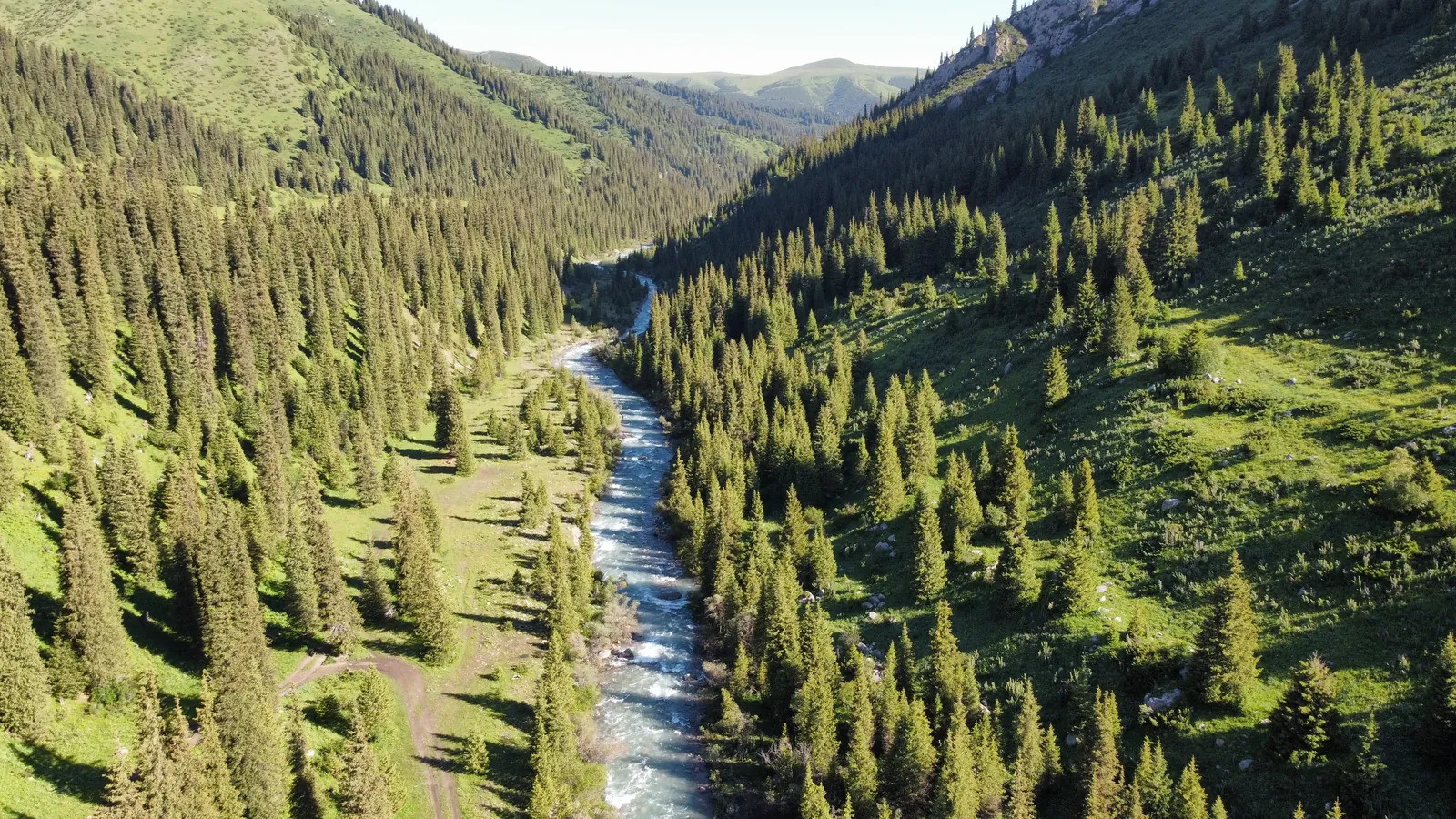 The Tekes River cutting through a forested valley, viewed from above
