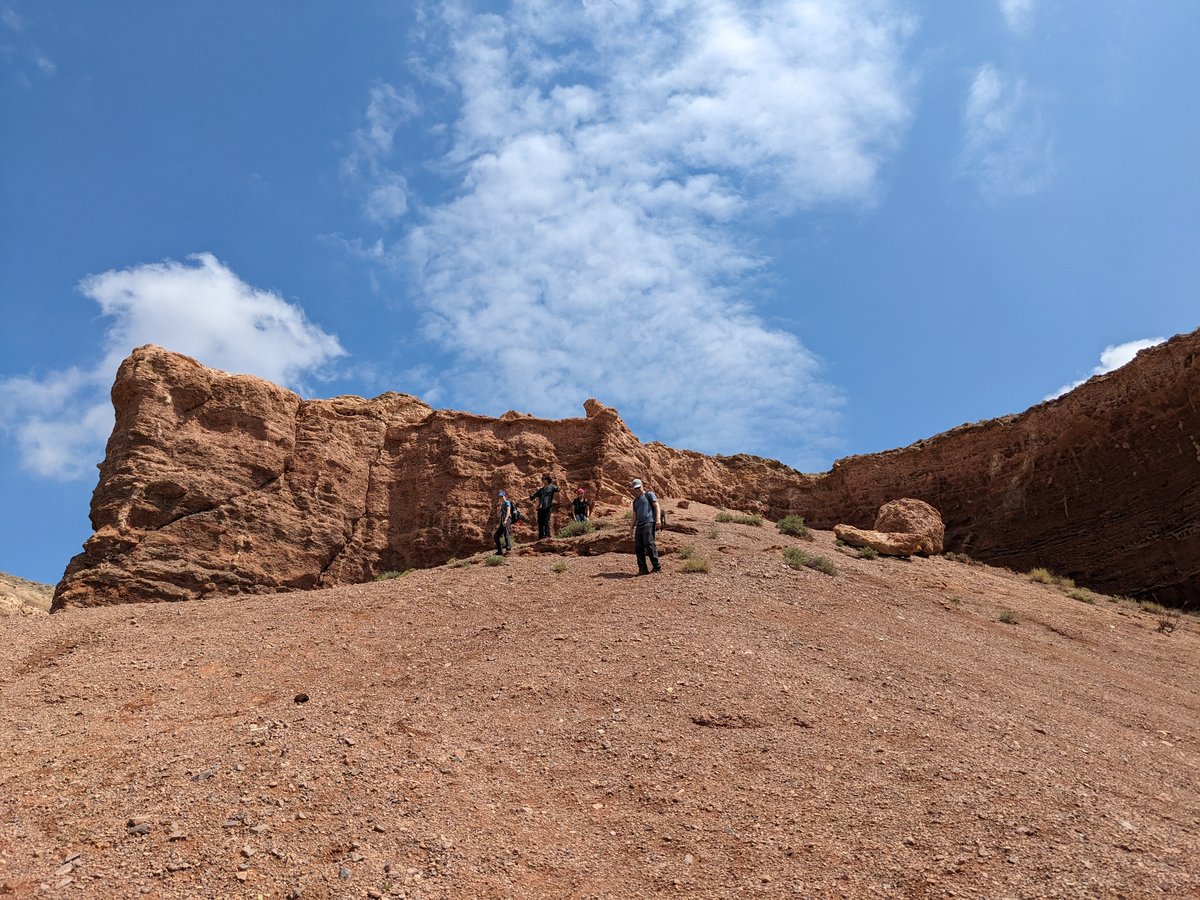 Guests hiking the Temirlik Canyon ridge under dramatic sky — private guided expedition